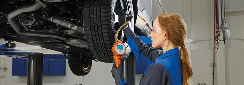 A Subaru technician checking tire pressure. | Mark Miller Subaru Midtown in Salt Lake City UT