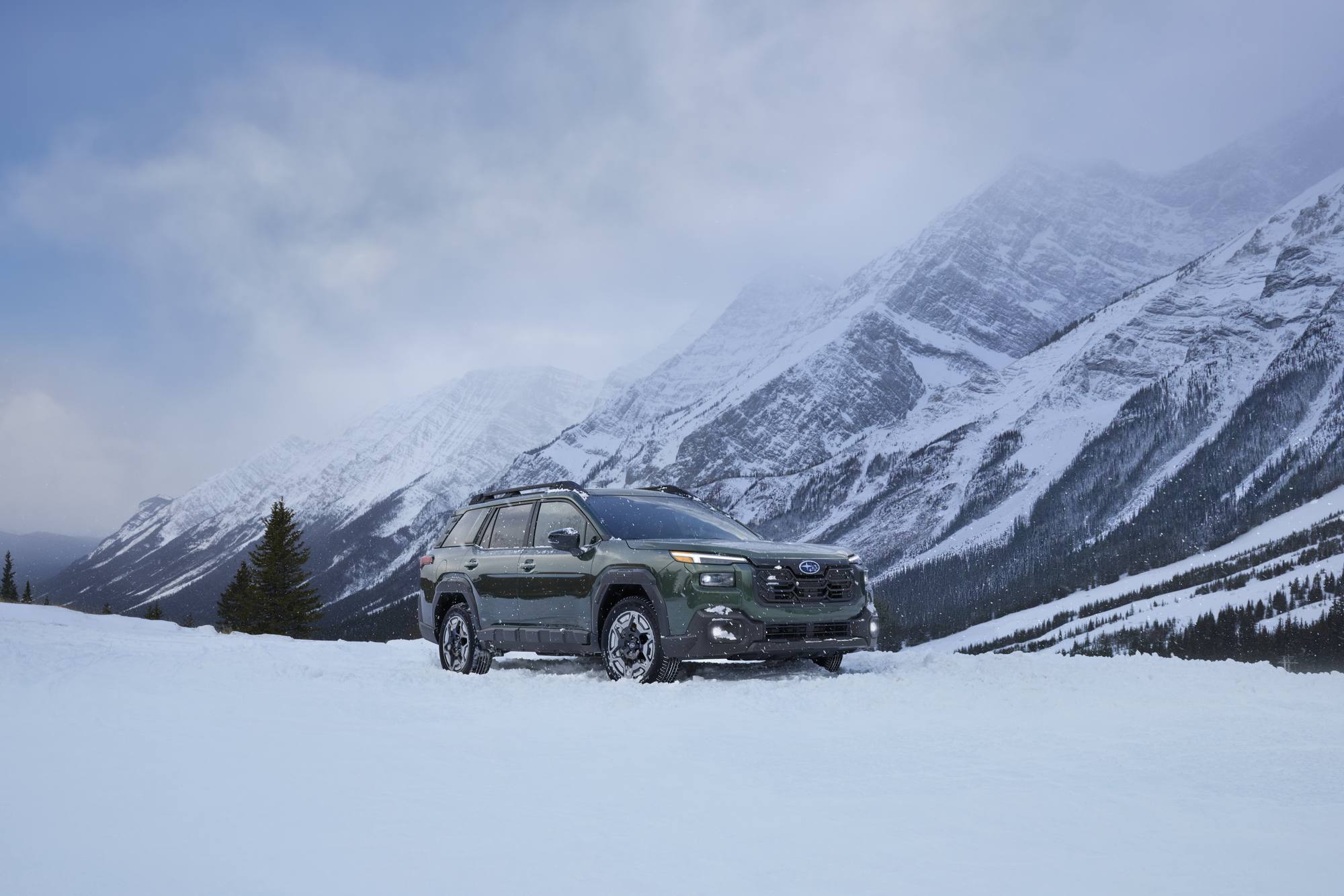 2026 Subaru Outback Wilderness parked on a snowfield below a Wasatch-style granite ridge